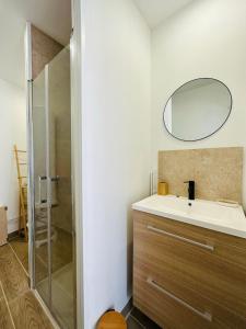 La salle de bains est pourvue d'un lavabo et d'une douche avec un miroir. dans l'établissement La ferme de la brutellette, à Woignarue