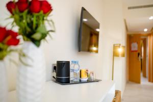 a counter with a coffee maker and a vase of red roses at Ari Boutique Hôtel - Adult Only in Marrakech