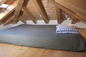 Una cama en un ático con una almohada. en Casa arancione a Burano, en Burano