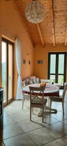 un soggiorno con tavolo, sedie e lampadario pendente di Ferienwohnung am Gardasee in Tignale, Pool, Seesicht, WLAN kostenlos a Tignale Altre 15 foto