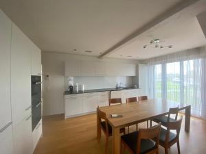 a kitchen and dining room with a table and chairs at Minergie in Rickenbach