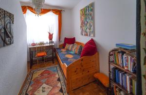 um pequeno quarto com uma cama e uma estante de livros em Ferienwohnung im Haus Lotus mit großem Balkon und Garten em Bad Urach