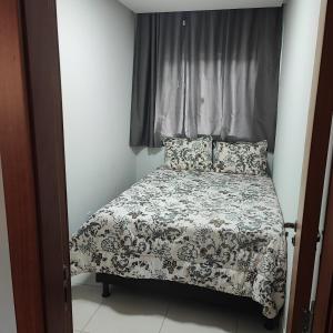 a bedroom with a bed with a black and white comforter at Recanto das Montanhas in Santa Teresa