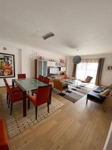 a living room with a dining room table and chairs at Atlantic Lodge, 1ª linha de praia! in Costa da Caparica