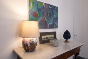 uma mesa com um candeeiro e uma pintura na parede em Home 29 Taormina City Center em Taormina