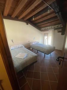 a bedroom with two beds in a room with wooden ceilings at La canongia in Segovia