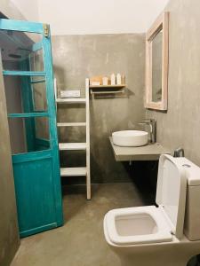 a bathroom with a blue door and a sink and a toilet at Mawella House 1807, Tangalle in Tangalle