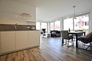 a kitchen and living room with a table and chairs at Villa Petersen Ankerplatz 3 in Wangerooge