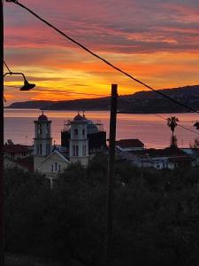 a sunset over a city with buildings and a street light at Erodios Apartments in Kalyves