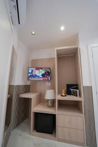 Una pequeña habitación con TV y una báscula de baño en P.C. Boutique H. De Gasperi, Napoli Centro, by ClaPa Group en Nápoles