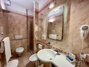 La salle de bains est pourvue d'un lavabo, de toilettes et d'un miroir. dans l'établissement Hotel Meridiana, à Marina di Campo