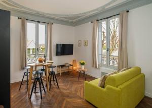 - un salon avec un canapé jaune et une table dans l'établissement Villa Forestière Studio Le Châtaignier, à Quincy-Voisins