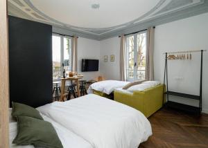 - une chambre avec deux lits et un canapé jaune dans l'établissement Villa Forestière Studio Le Châtaignier, à Quincy-Voisins