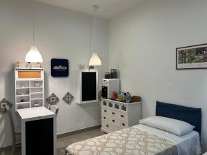 - une chambre avec un lit, un bureau et un réfrigérateur dans l'établissement Prestige, à Naples