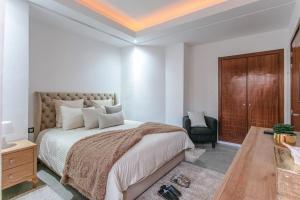 a bedroom with a large bed and a chair at Elite Escape - Marrakech Centre in Marrakech