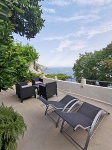 Villa Mirella Sea View Apartments في بوسيتانو: فناء مع كراسي وإطلالة على المحيط