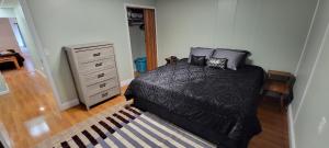 1 dormitorio con cama negra y vestidor en Cattaraugus, Home sweet home!, en Cattaraugus