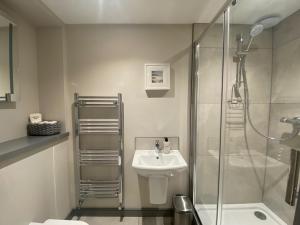 W łazience znajduje się szklana kabina prysznicowa i umywalka. w obiekcie The Old Gables w mieście Brampton