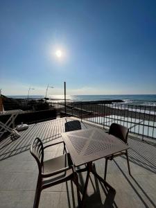 een tafel en stoelen naast een strand met de maan bij Chéry Holiday Home in Riva Ligure