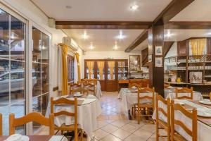 a restaurant with tables and chairs in a room at Pousada Monte Felice Recanto da Lua in Gramado