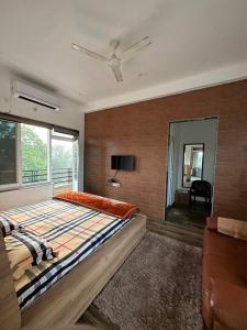 a bedroom with a large bed and a window at Kaashi Flora (Modern Suite) in Varanasi
