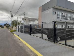 a fence with a van parked next to a building at Loft01 com garagem, Wi-fi, 25 min de Aparecida in Pindamonhangaba
