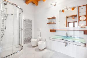 La salle de bains est pourvue d'un lavabo, d'une douche et de toilettes. dans l'établissement La Fortezza Apartment, à Peschiera del Garda