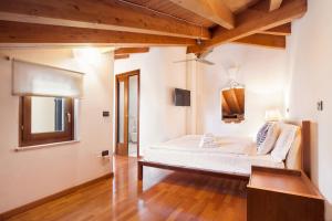 - une chambre avec un lit dans une pièce dotée de plafonds en bois dans l'établissement La Fortezza Apartment, à Peschiera del Garda