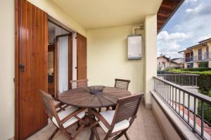 d'une table et de chaises en bois sur un balcon. dans l'établissement La Fortezza Apartment, à Peschiera del Garda