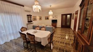 a dining room with a white table and chairs at La casa di nonna Carmelina in Milazzo