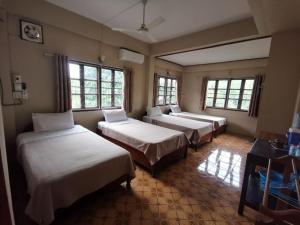 a room with four beds in a room with windows at Sabaydee Guesthouse in Ban Houayxay