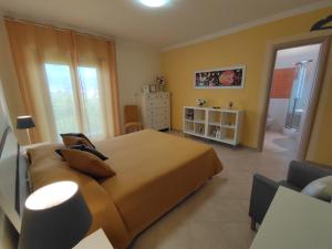 - une chambre avec un grand lit orange et une commode dans l'établissement Il Giardino delle Zagare, à Fondi