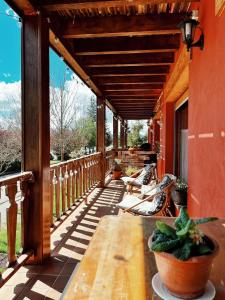 een houten veranda met een tafel en banken erop bij Apartaments Cel i Fusta in Camprodon