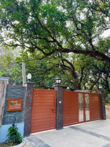 a orange gate with a tree behind it at Kaashi Flora (Modern Suite) in Varanasi