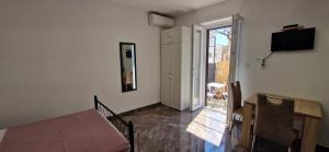 Habitación con mesa y puerta a un balcón. en Apartments Petar Komiza, en Komiža