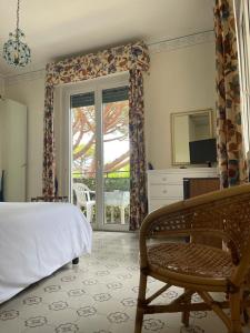 a bedroom with a bed and a chair and a window at Piccolo Hotel in Forte dei Marmi