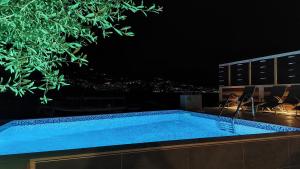 a swimming pool on top of a building at night at Apartments Sutorina in Herceg-Novi