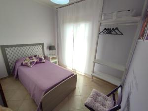 - une chambre avec un lit violet et une fenêtre dans l'établissement Il Giardino delle Zagare, à Fondi