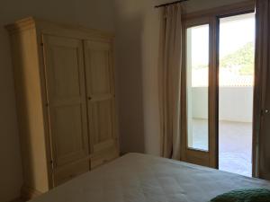 a bedroom with a bed and a large window at Appartamento Sasimedda in San Pantaleo
