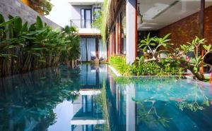 - une piscine au milieu d'un immeuble avec des plantes dans l'établissement K-House vs Apartment, à Đà Nẵng
