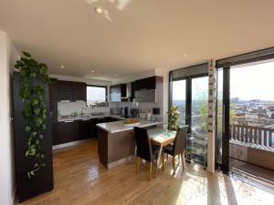 una cucina e una sala da pranzo con tavolo e sedie di Penthouse in Battersea amazing views of London a Londra