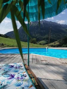 a bed on a wooden deck next to a swimming pool at Chambre Trèfle in Entremont