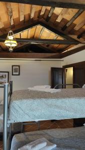 1 dormitorio con 2 camas y techo de madera en La canongia en Segovia