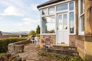 Casa con puerta blanca y patio en Lochinver, en Crieff