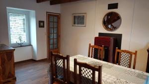 a dining room with a table and chairs and a window at le Milin Du in Gouarec