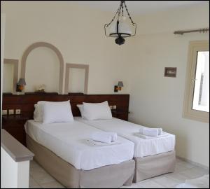 a bedroom with a large white bed with two towels at La Luna Apartments in Stalís