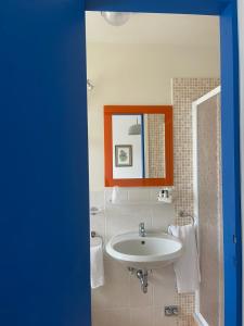 a bathroom with a sink and a mirror at Piccolo Hotel in Forte dei Marmi