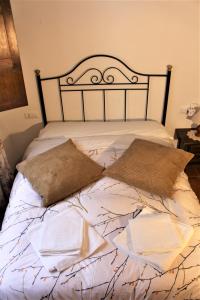 Una cama con dos almohadas encima. en Refugio del Chorrito, en Grazalema