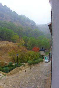 - une vue sur la montagne avec une voiture garée dans une rue dans l'établissement Refugio del Chorrito, à Grazalema