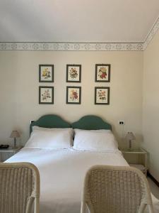 a bedroom with a large bed with three pictures on the wall at Piccolo Hotel in Forte dei Marmi
